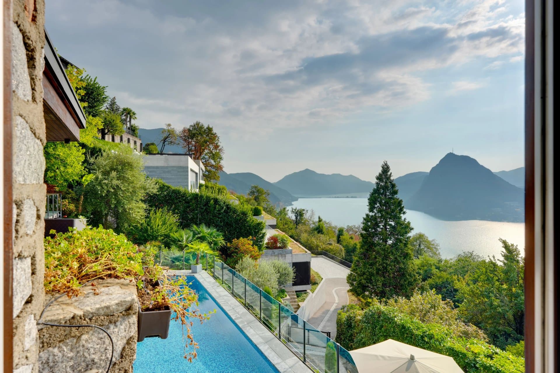 Completely refurbished, this extraordinary villa for sale in Lugano-Aldesago, designed by architect Franco Ponti, stands out for its iconic triangular forms and the refined interplay of natural stone… - 2